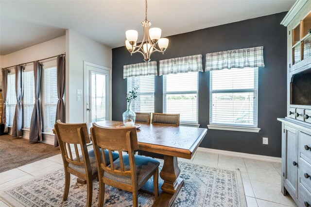 tiled dining room with a chandelier and plenty of natural light