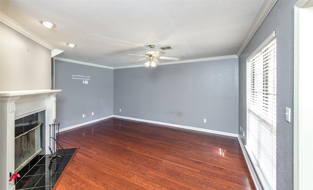 unfurnished living room featuring dark wood-type flooring, a tile fireplace, ceiling fan, ornamental molding, and a textured ceiling