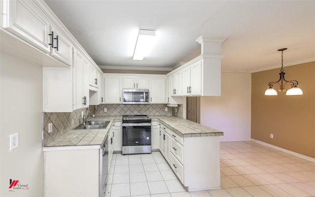 kitchen with stainless steel appliances, sink, white cabinetry, hanging light fixtures, and light tile patterned flooring