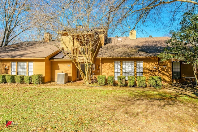 view of front of home with central AC and a front lawn