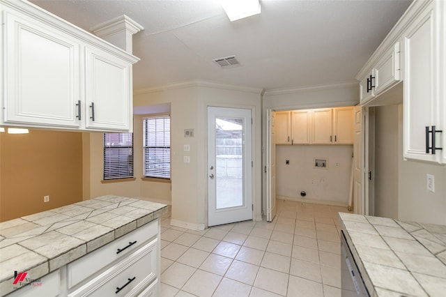 kitchen featuring tile countertops, light tile patterned flooring, white cabinetry, and crown molding