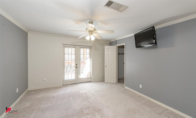 empty room featuring ceiling fan, french doors, light colored carpet, and ornamental molding