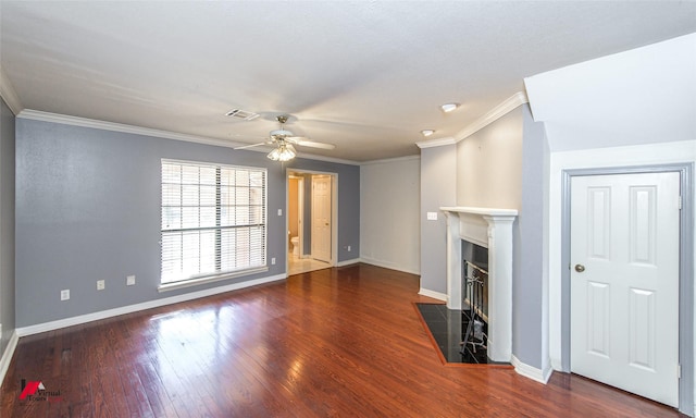 unfurnished living room featuring ceiling fan, ornamental molding, a fireplace, and dark wood-type flooring