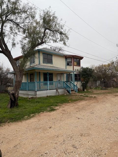 rear view of property featuring covered porch