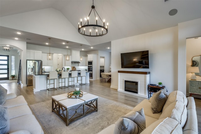 living room with high vaulted ceiling and light wood-type flooring