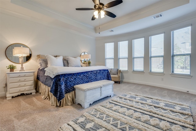 bedroom featuring ornamental molding, a tray ceiling, ceiling fan, multiple windows, and carpet floors