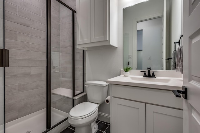 bathroom featuring tile patterned flooring, vanity, toilet, and walk in shower