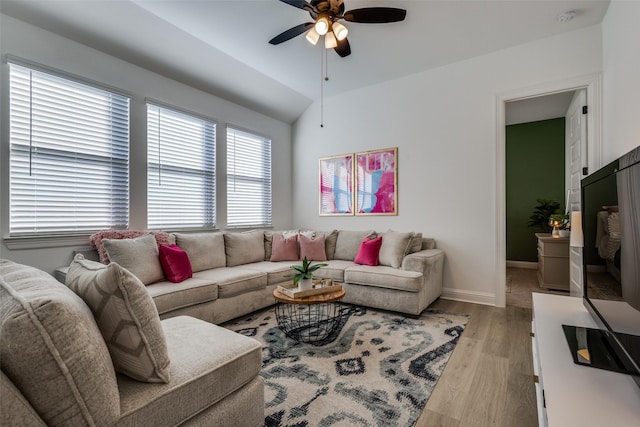 living room featuring ceiling fan, light hardwood / wood-style floors, and lofted ceiling