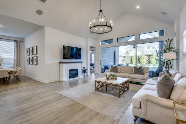 living room featuring a chandelier, a high ceiling, and light wood-type flooring