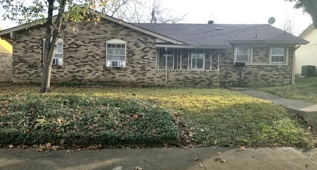 view of front of home with central AC unit and a front yard