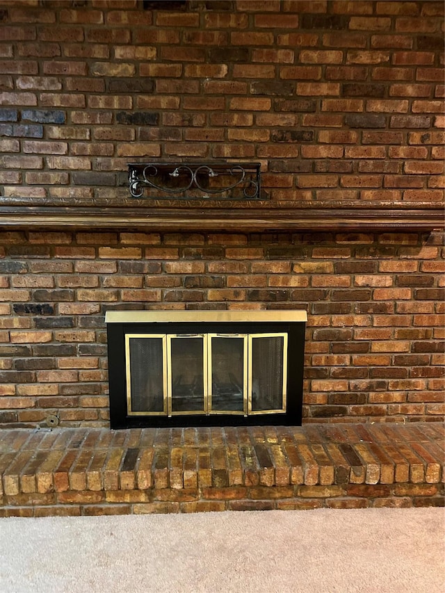 interior details with carpet floors and a fireplace