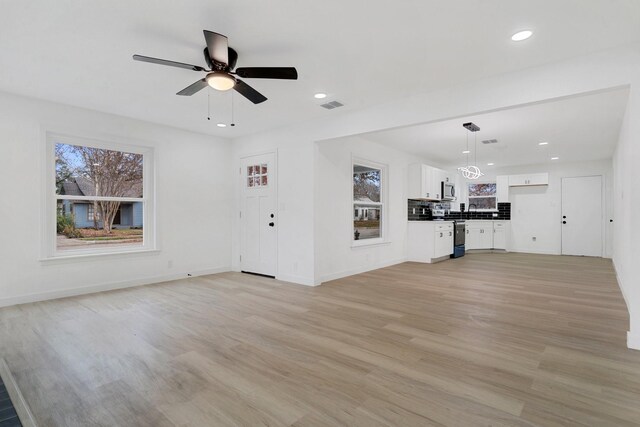 unfurnished living room with ceiling fan and light hardwood / wood-style floors