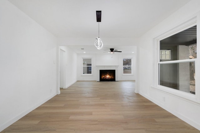 unfurnished living room featuring ceiling fan and light hardwood / wood-style floors