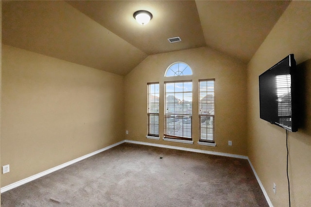 unfurnished room featuring lofted ceiling and carpet floors