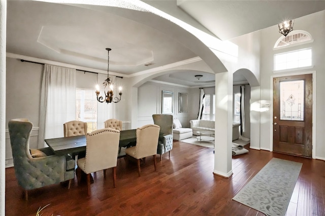 dining room with an inviting chandelier, dark hardwood / wood-style floors, and a raised ceiling