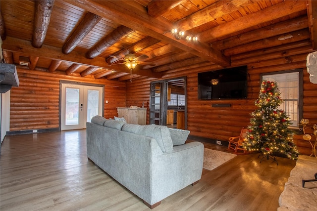 living room featuring french doors, rustic walls, ceiling fan, and wooden ceiling