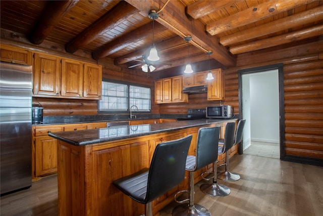 kitchen featuring a breakfast bar, wood ceiling, decorative light fixtures, a center island, and appliances with stainless steel finishes