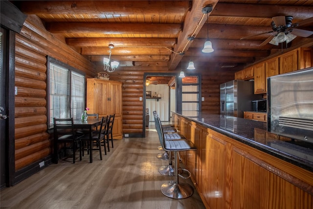 kitchen featuring log walls, pendant lighting, wooden ceiling, beamed ceiling, and stainless steel fridge with ice dispenser