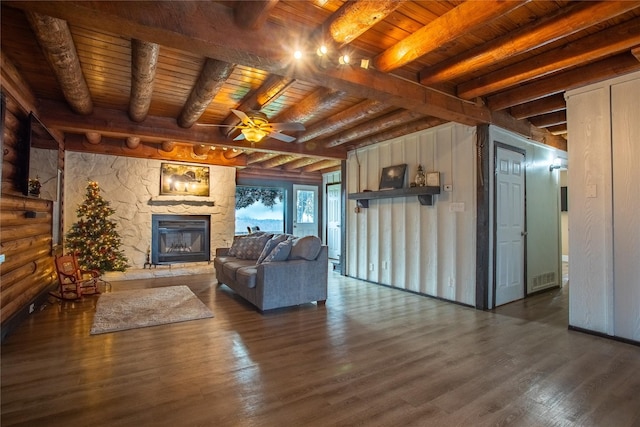 unfurnished living room with dark wood-type flooring, a stone fireplace, wooden ceiling, ceiling fan, and beam ceiling