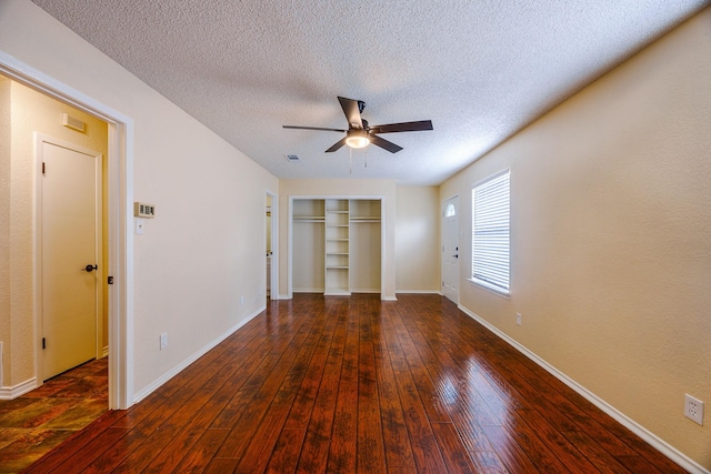 unfurnished bedroom with dark wood-type flooring, a closet, ceiling fan, and a textured ceiling