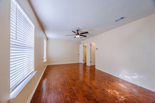 unfurnished room with dark wood-type flooring, ceiling fan, and a textured ceiling