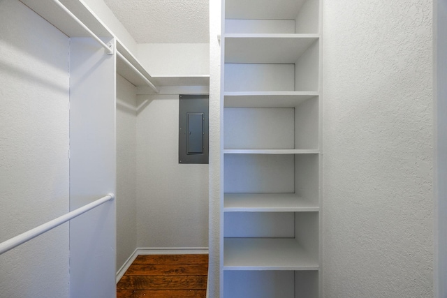 spacious closet featuring dark wood-type flooring and electric panel