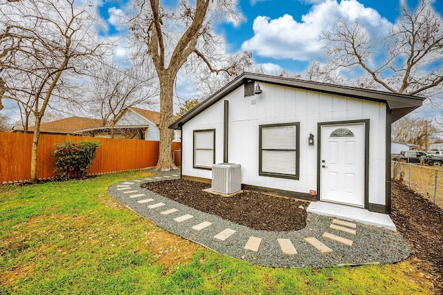 view of outdoor structure with a lawn and central air condition unit