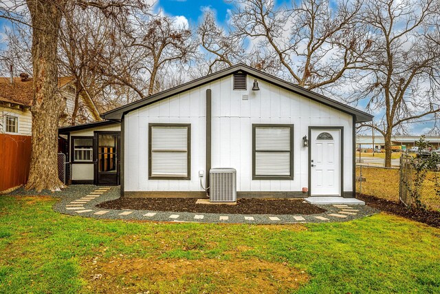 rear view of property with a yard and central air condition unit