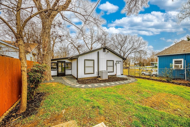 exterior space with central AC unit and a lawn