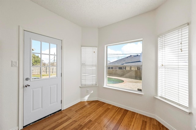 doorway to outside featuring hardwood / wood-style flooring and a textured ceiling