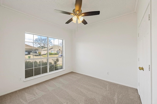 unfurnished room with ornamental molding, carpet, and ceiling fan