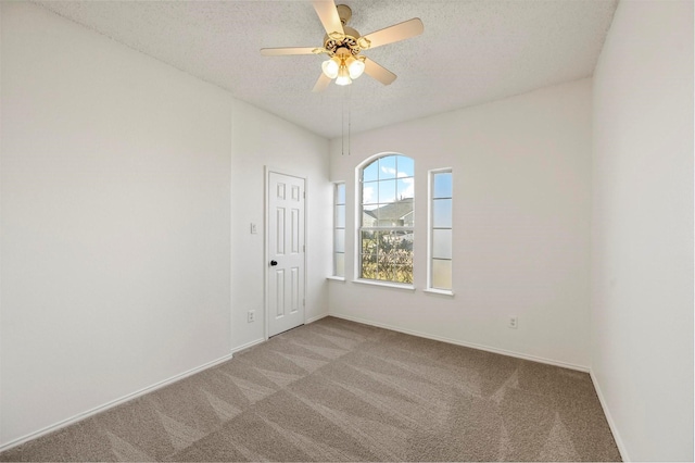 carpeted spare room with ceiling fan and a textured ceiling