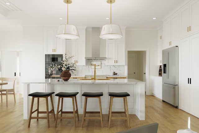 kitchen featuring backsplash, wall chimney range hood, high end refrigerator, light wood-style floors, and white cabinets