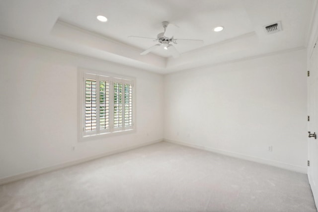 unfurnished room with carpet flooring, ceiling fan, and a raised ceiling