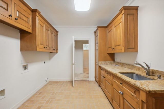 kitchen featuring light stone countertops, crown molding, and sink