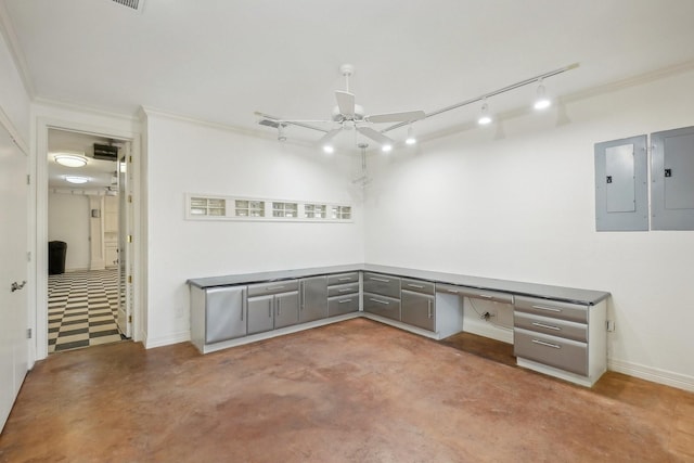 unfurnished room featuring built in desk, ornamental molding, electric panel, and concrete flooring