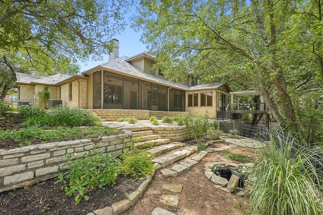 back of property with a sunroom