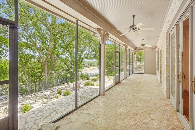 unfurnished sunroom featuring ceiling fan