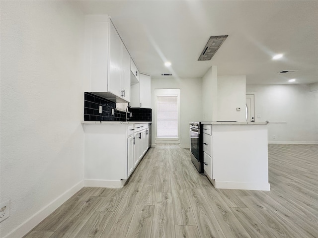 kitchen with backsplash, light hardwood / wood-style floors, white cabinetry, and sink