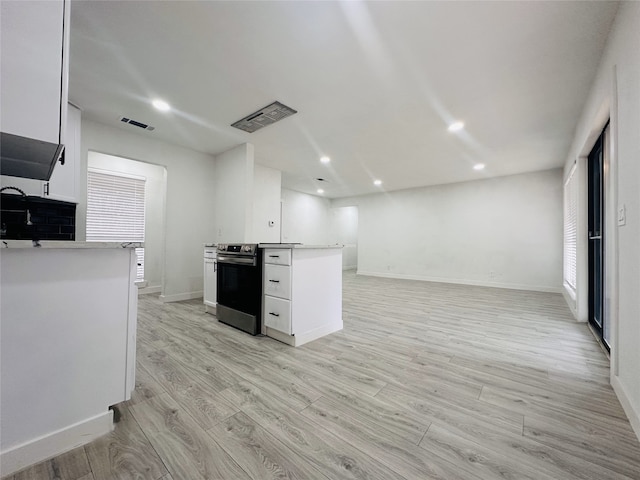 kitchen with white cabinets, light wood-type flooring, electric range, and sink