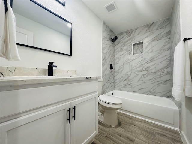 full bathroom with toilet, wood-type flooring, vanity, and tiled shower / bath combo