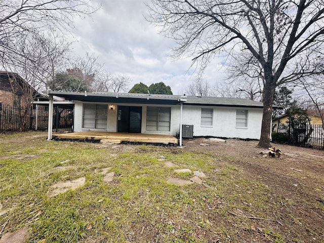 rear view of property featuring a lawn