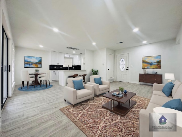 living room featuring light hardwood / wood-style floors and sink