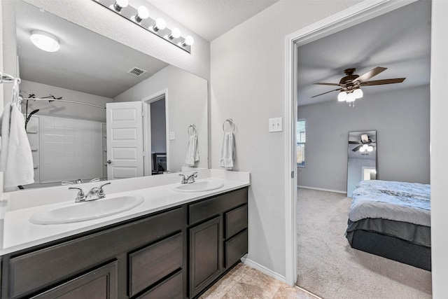 bathroom with a textured ceiling, ceiling fan, walk in shower, and vanity