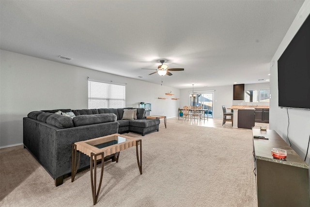 living room featuring ceiling fan and light colored carpet