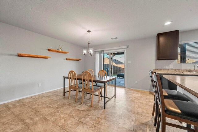 dining space with a notable chandelier and sink