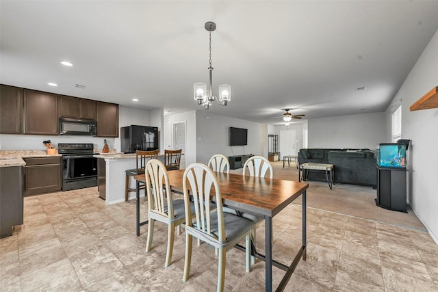 dining space with ceiling fan with notable chandelier