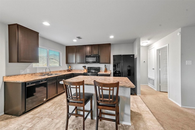 kitchen featuring light carpet, black appliances, a kitchen island, dark brown cabinets, and sink