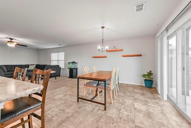 dining area with ceiling fan with notable chandelier