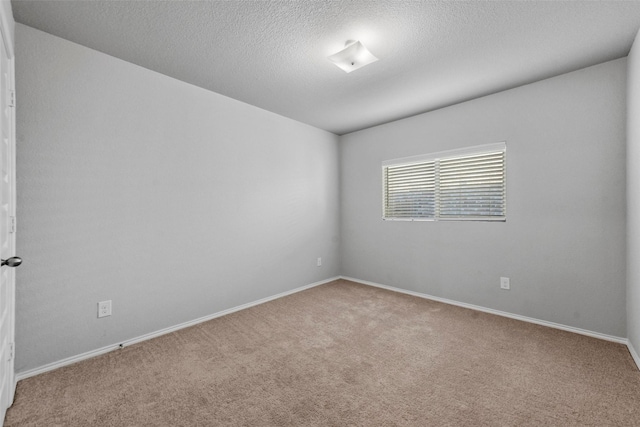 empty room featuring a textured ceiling and light carpet